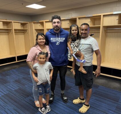 RCMA members meet Tampa Bay Lightning player Nick Paul in the locker room during Noche Latina at Amalie Arena, celebrating Hispanic culture and community.